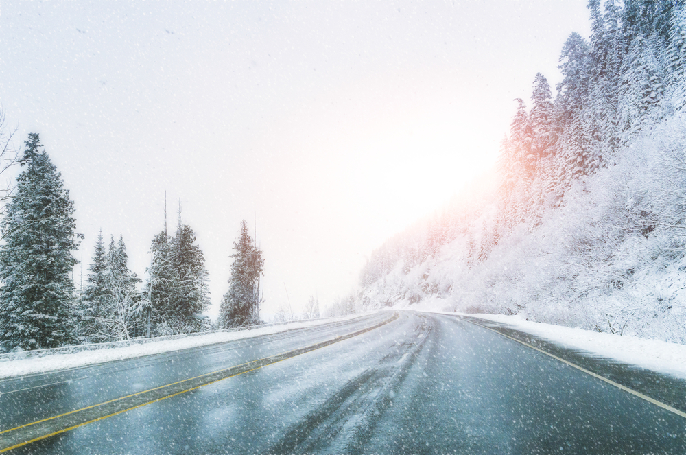 scenic-view-of-empty-road-with-snow-covered-landscape-while-snowing-in-winter-season