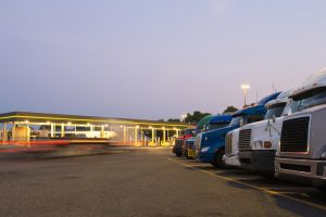 semi trucks at a truck stop in the evening