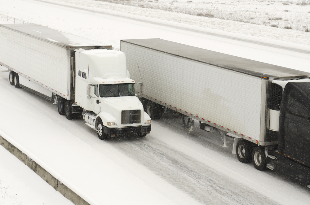 Semi truck traffic on Interstate 5 during a winter snow and freezing rain storm