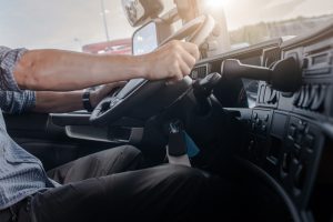 Caucasian Men Behind Semi Truck Steering Wheel. Cabin Interior