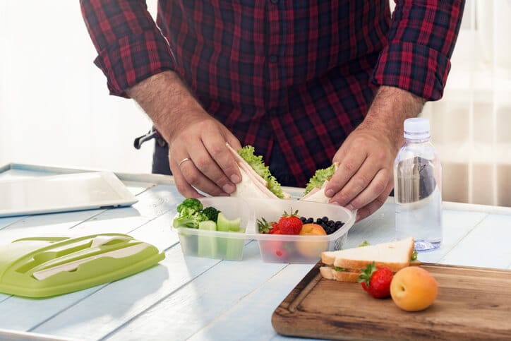 man meal prepping snacks and sandwich